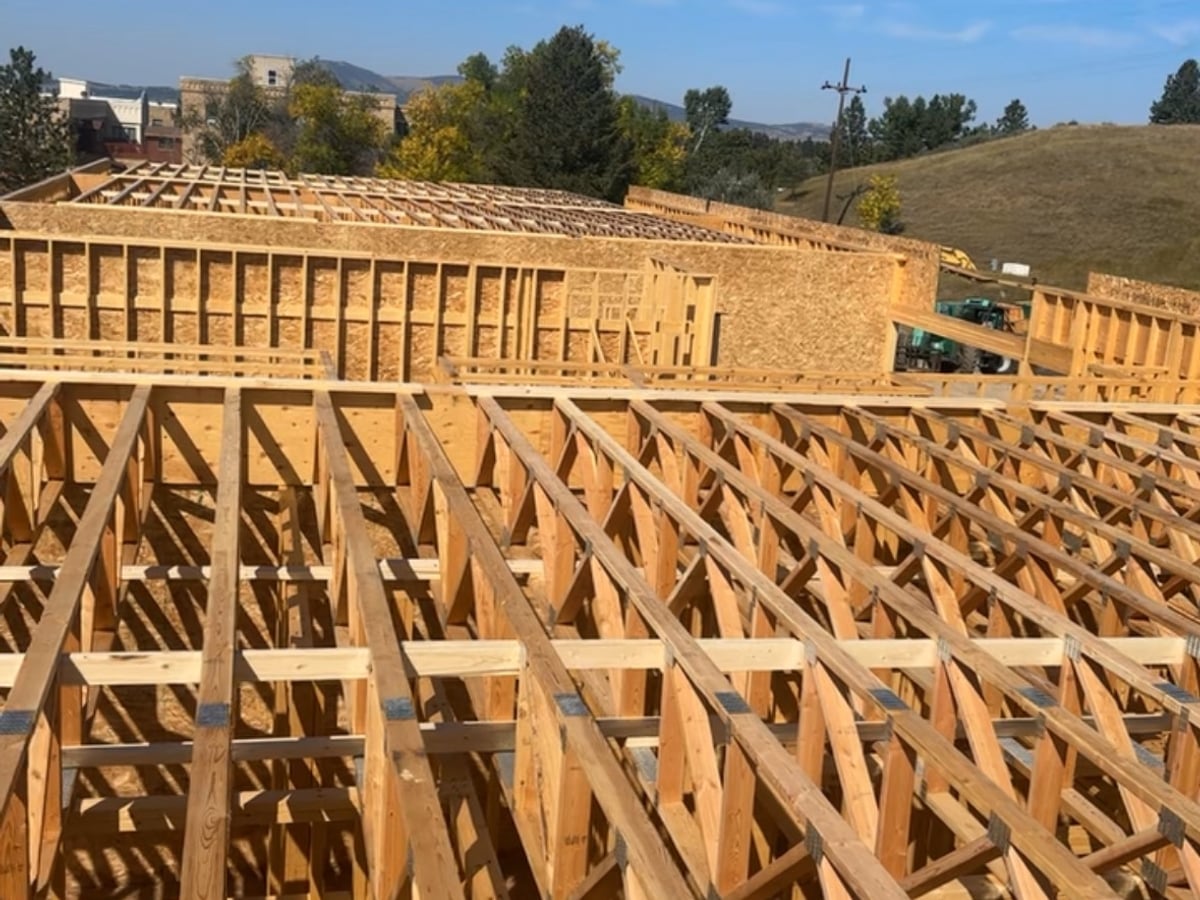 Floor joist framing for custom home in Missoula, Montana with mountain backdrop