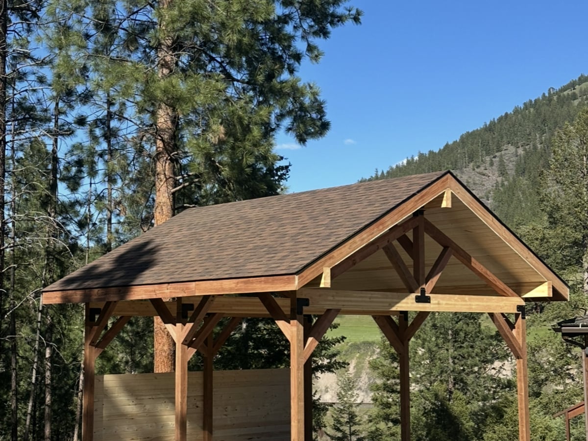 Timber-frame pavilion with shingle roof, custom outdoor structure in Western Montana
